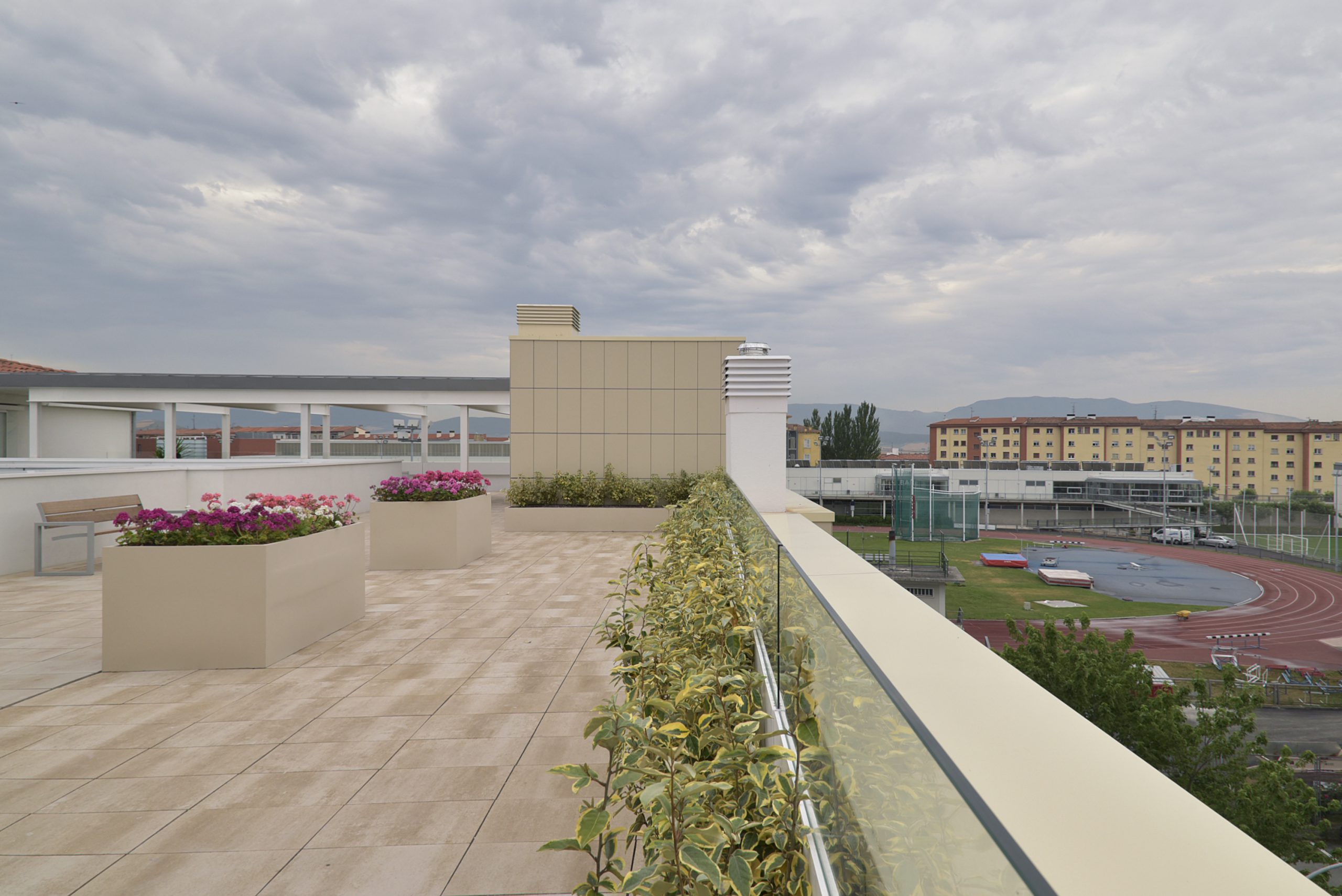 Proyecto de Rehabilitación de la Residencia San Fermín en Pamplona (Navarra). Terraza en el ático del edificio adecuada para dar paseos y sentarse en uno de los bancos instalados para disfrutar de las vistas panorámicas de las que posee este edificio.