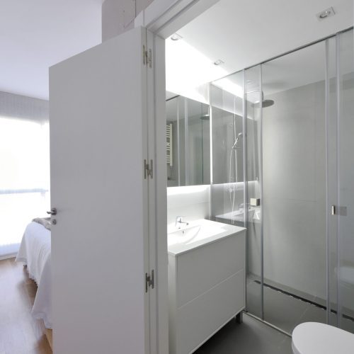 Proyecto de Reforma íntegra de baño en Zizur Menor (Navarra). Espacio pequeño iluminado con luz indirecta, donde el blanco es el único color para no agobiar. Diseño lineal, limpio y actual.